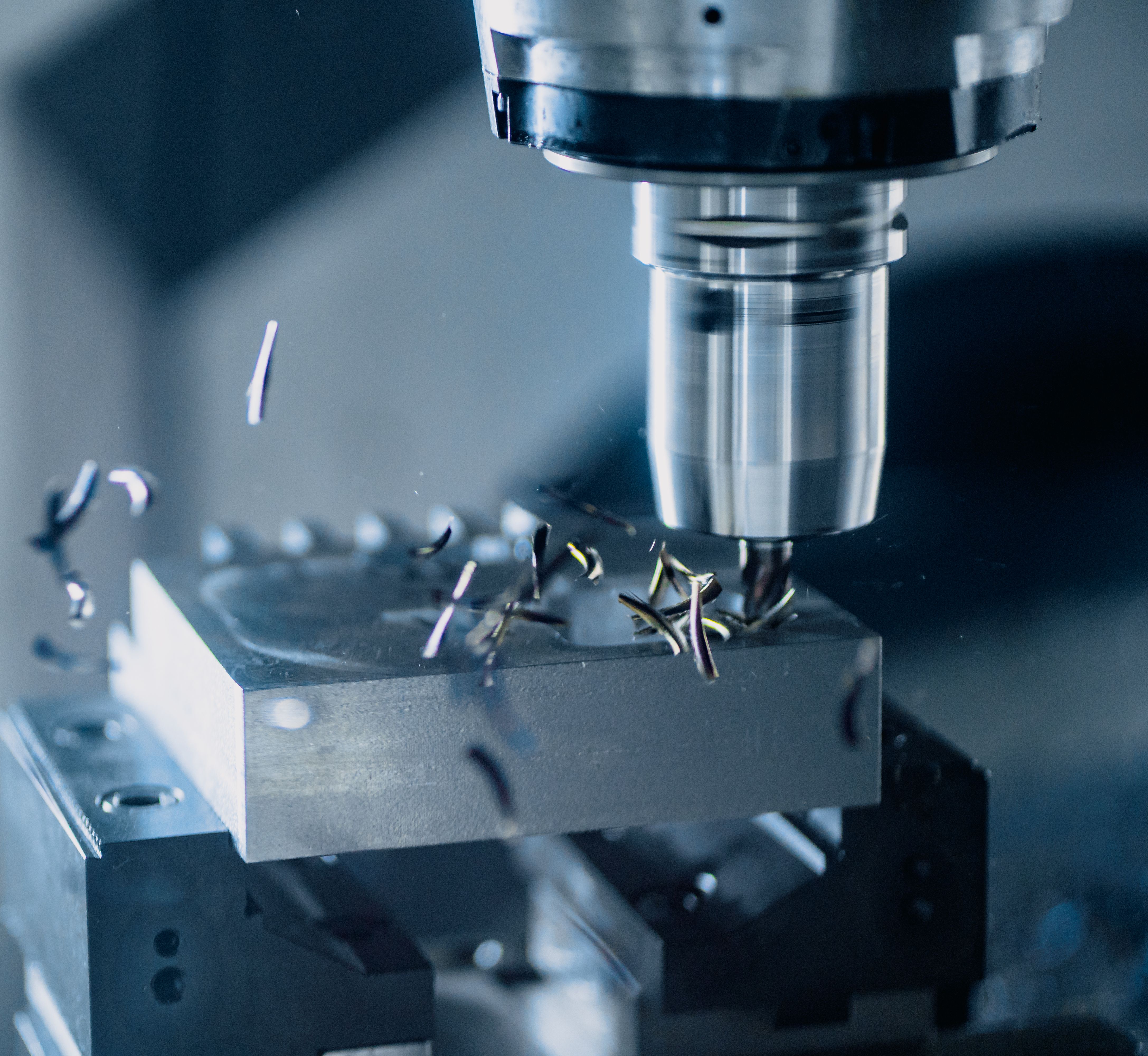 Torn CNC mecanitzant una peça metàl·lica.